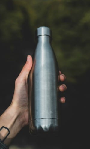 person holding gray bottle